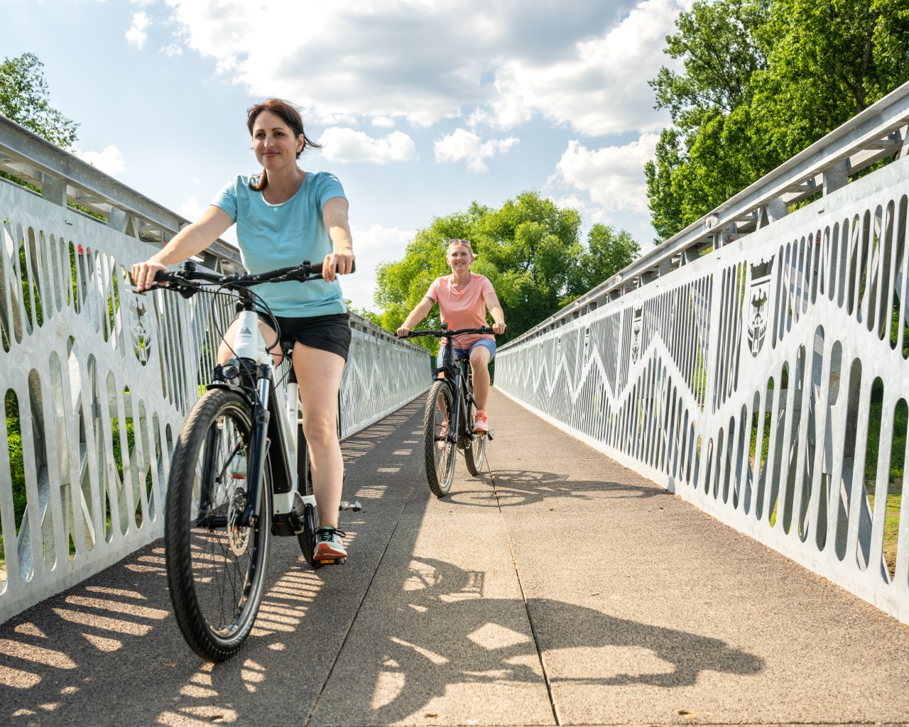 Radfahrerinnen auf der Brücke über die Ahr bei Sinzig | © Dominik Ketz (CC BY SA 4.0, https://creativecommons.org/licenses/by-sa/4.0) Radfahrerinnen auf der Brücke über die Ahr bei Sinzig | © Dominik Ketz (CC BY SA 4.0, https://creativecommons.org/licenses/by-sa/4.0)
