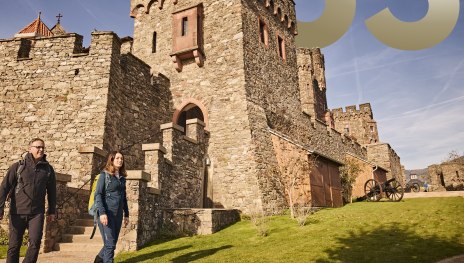 Wanderer vor Burg Reichenstein | © Marco Rothbrust Wanderer vor Burg Reichenstein | © Marco Rothbrust